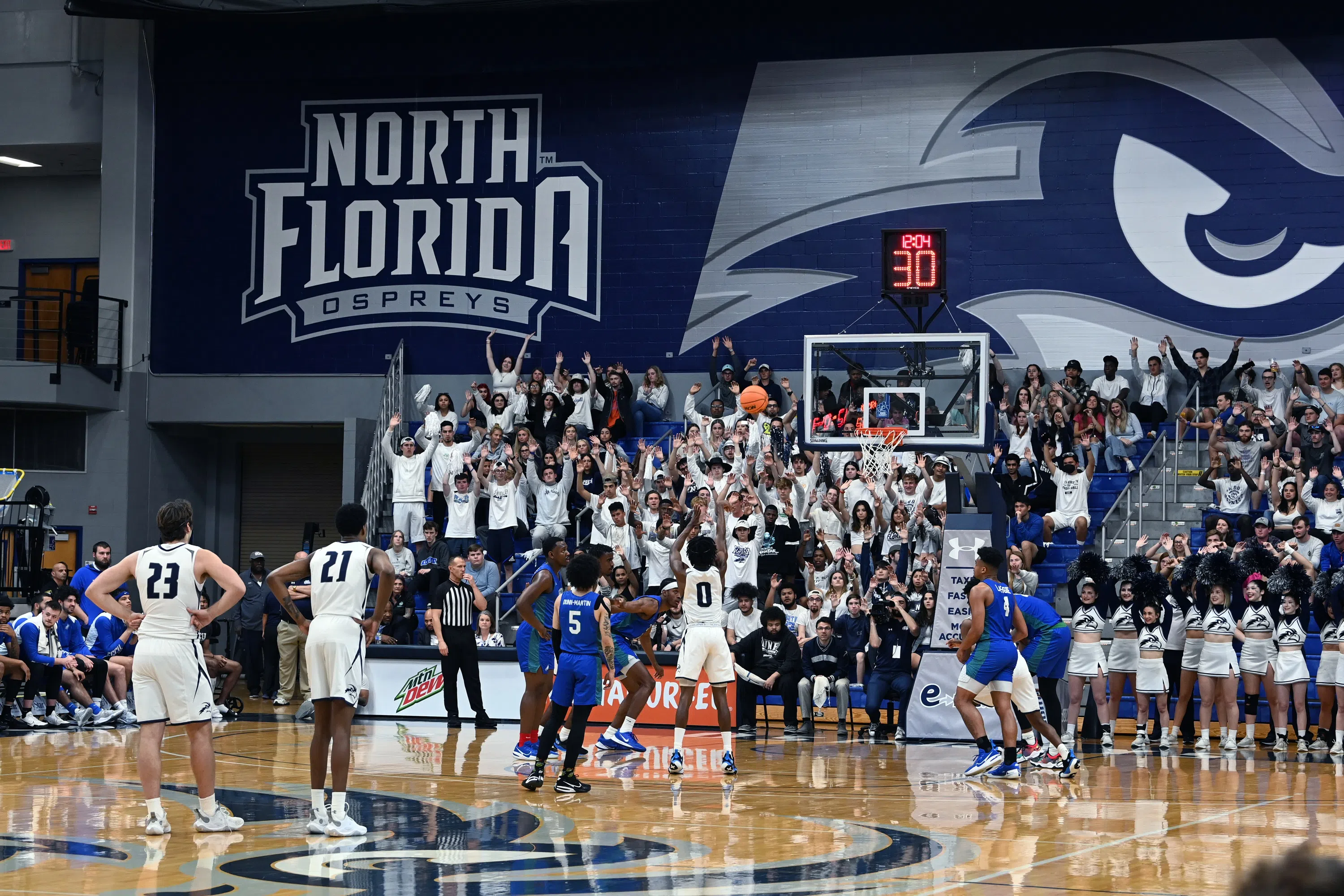 basketball game with students holding hands up