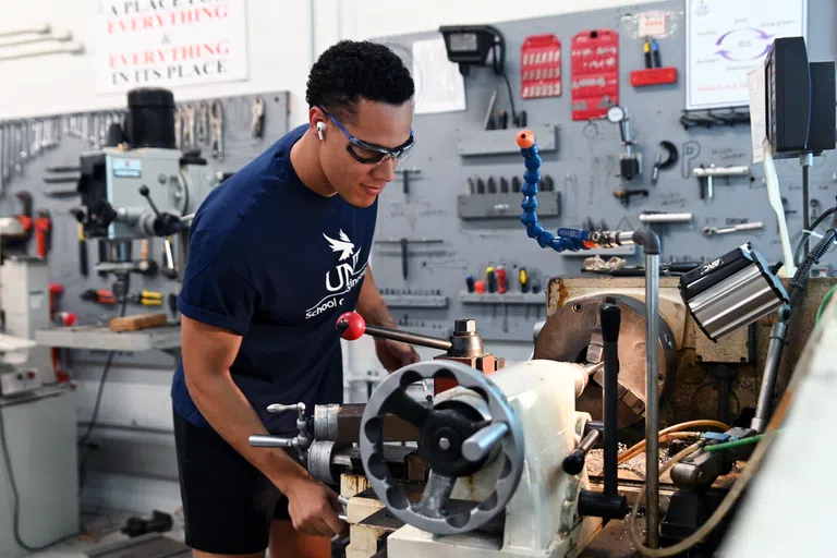 Student wearing School of Engineering shirt working on lab