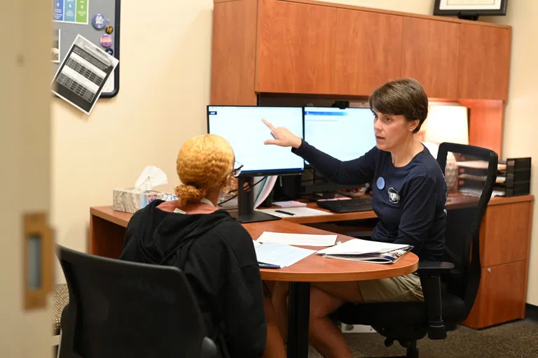 Student and first-year advisor talking about information on the computer