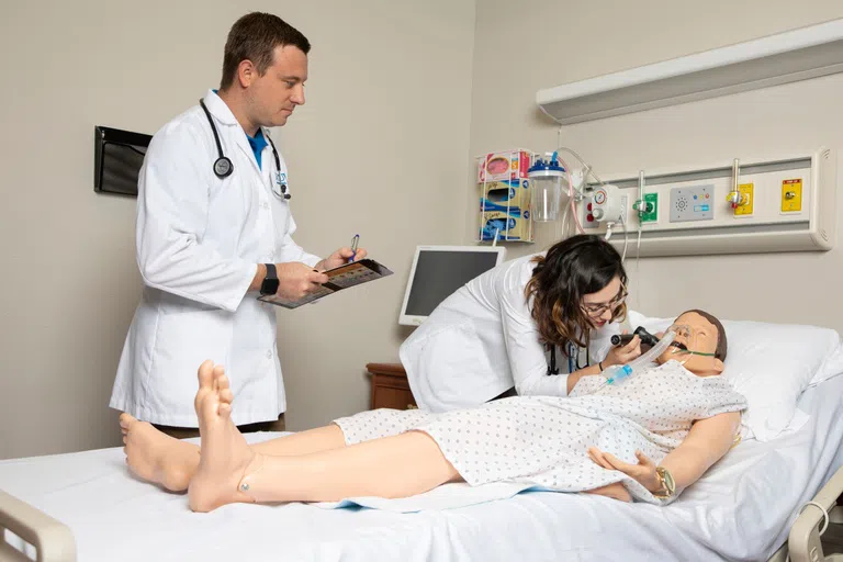 Student examining a simulated patient.