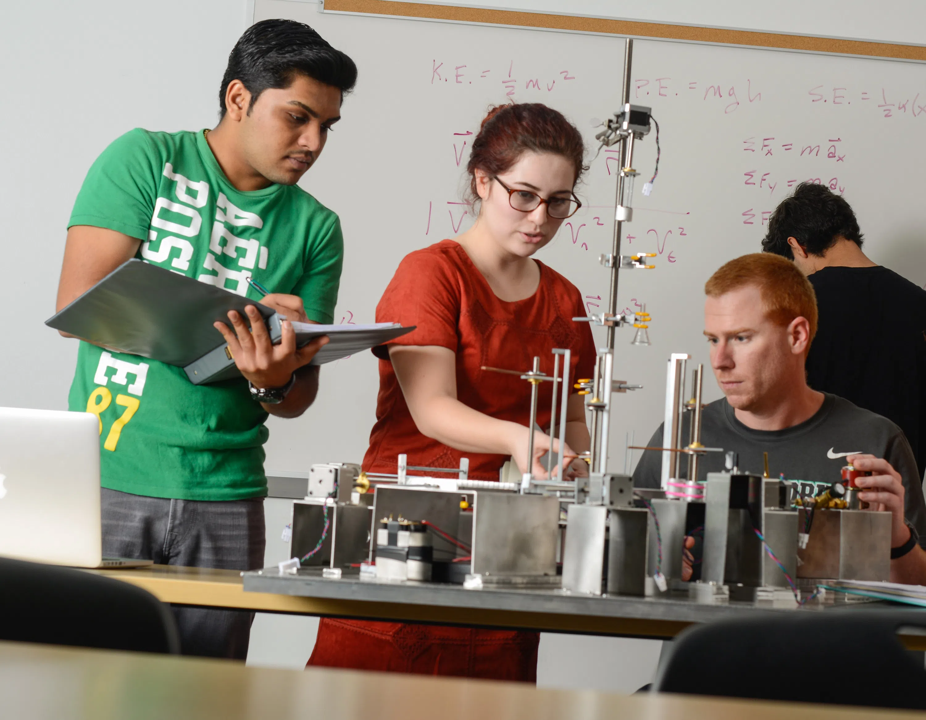 Students working on a mechanical engineering project in a lab.