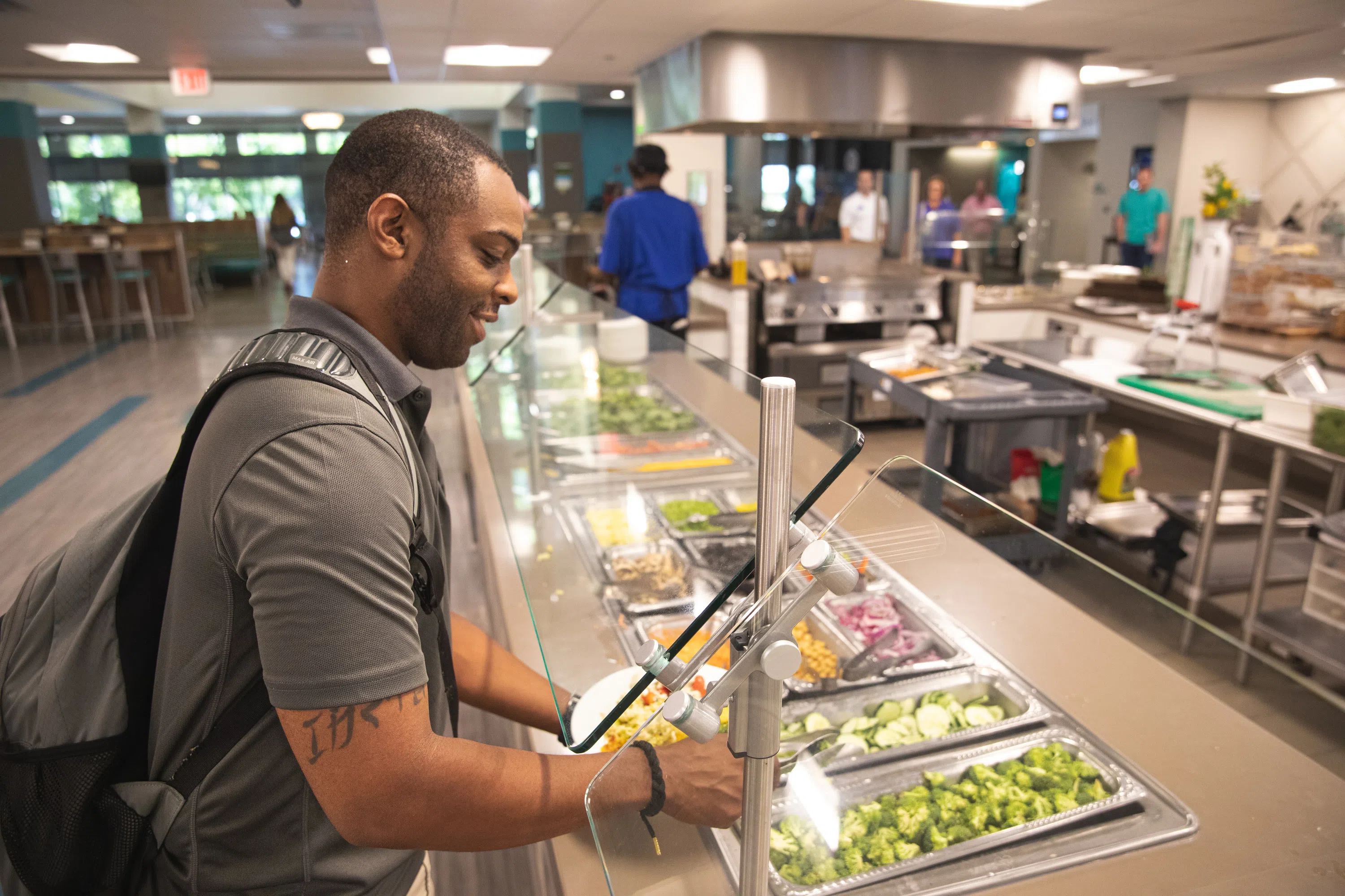 Student making a salad from the salad bar in the Nautilus Market.