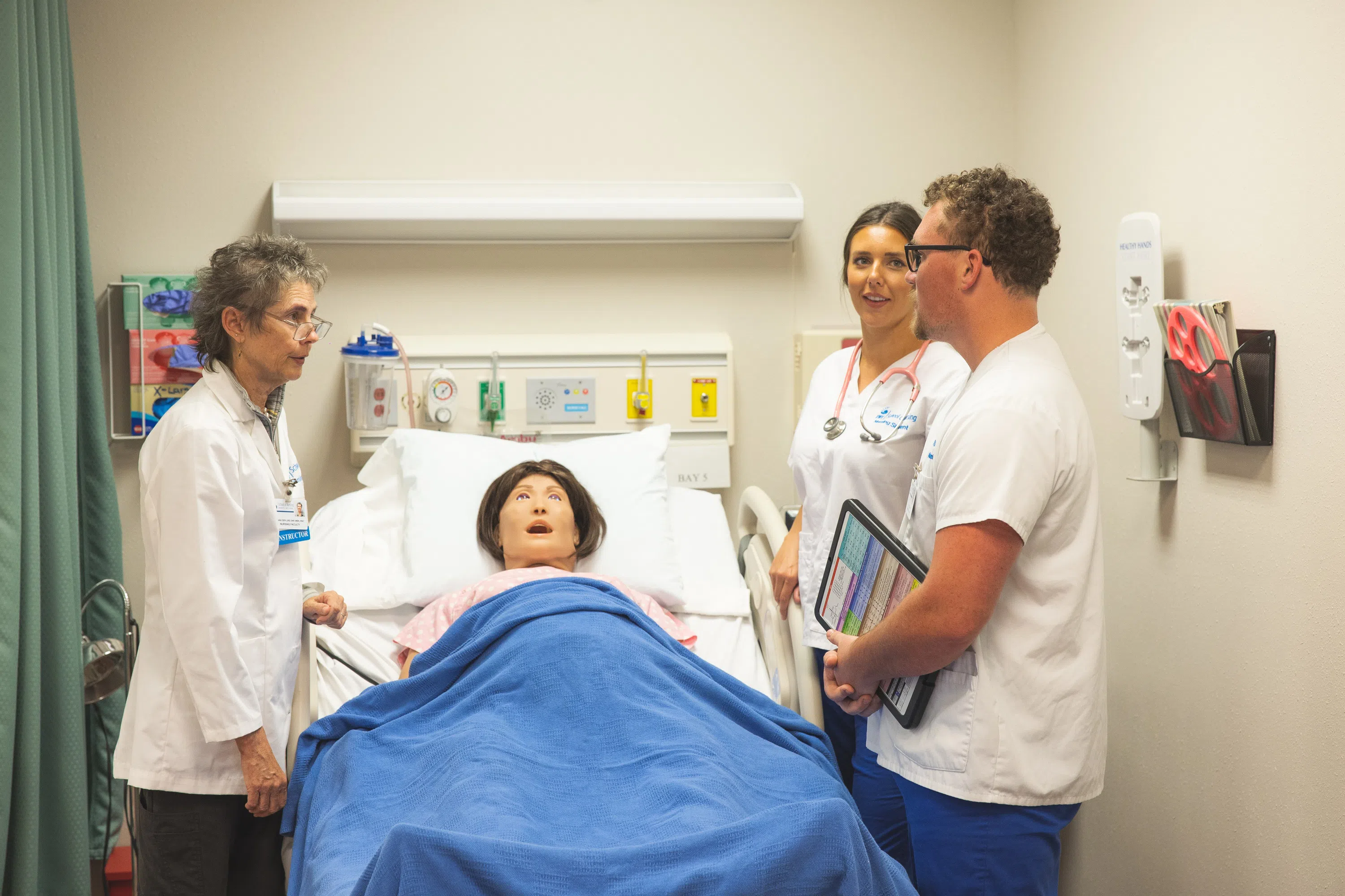 Nursing students interact with simulated patient.