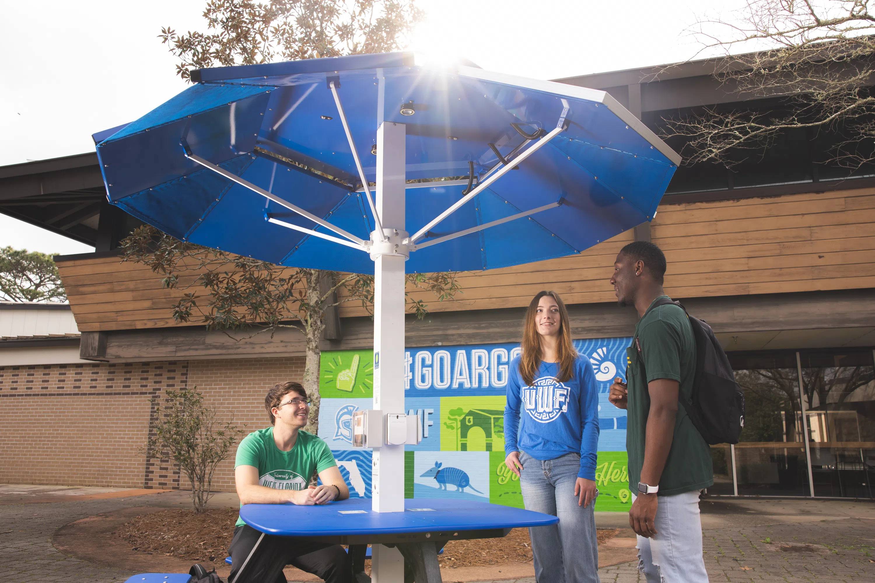 Students chatting outside the Commons in front of the #GoArgos Mural