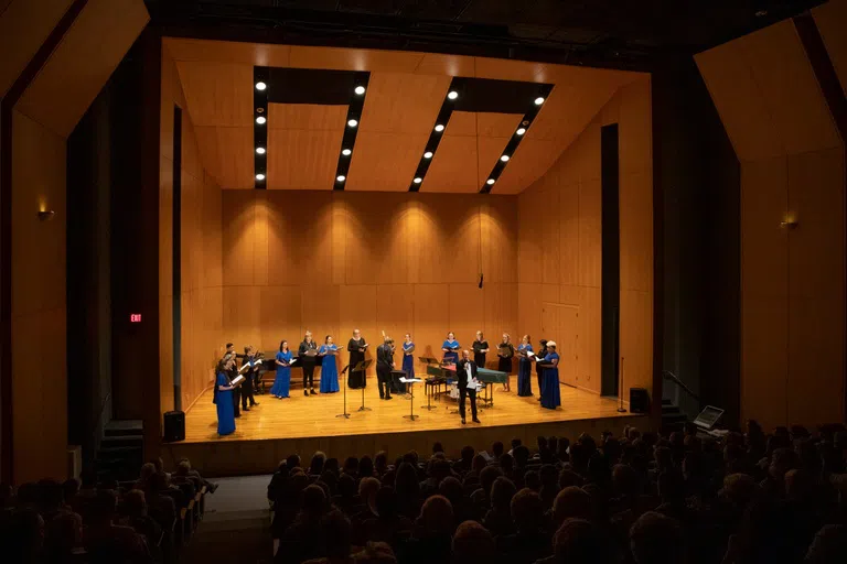 Singers performing on stage in the music hall