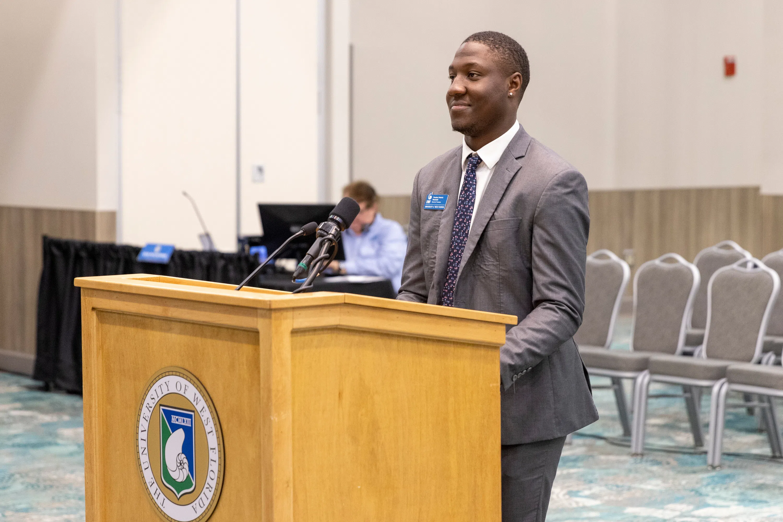 Student speaking in at a podium in the conference center