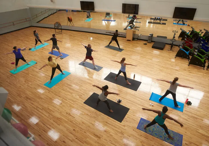 Students participate in the Hatha Yoga class in the Blue Studio at the Health Leisure and Sport Facility.