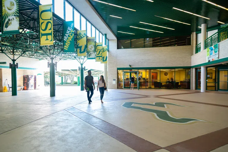 Students walking through the square with Bulls logo on the floor.