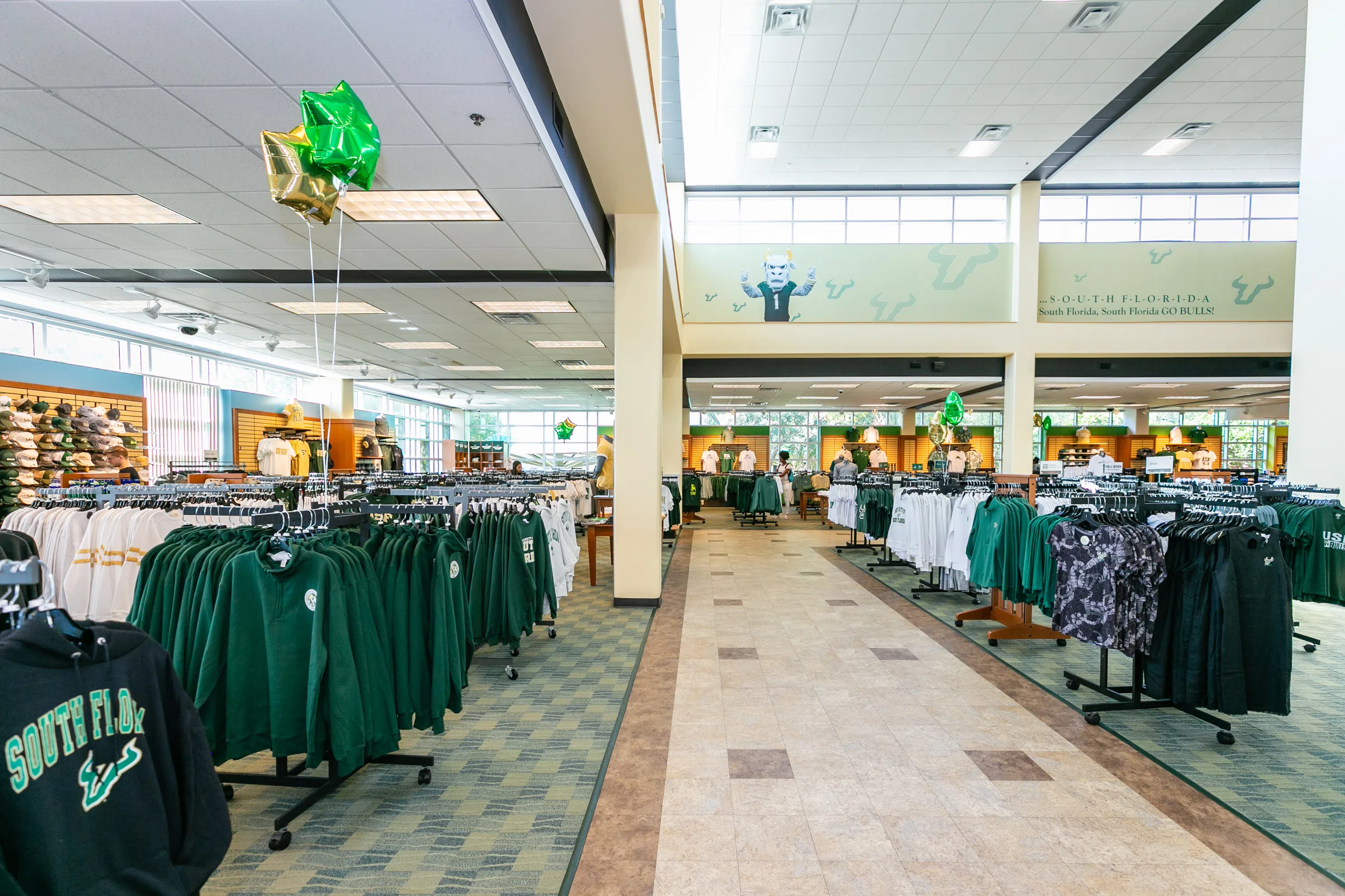 Green, gold and white merchandise all spread throughout the store on sale racks.