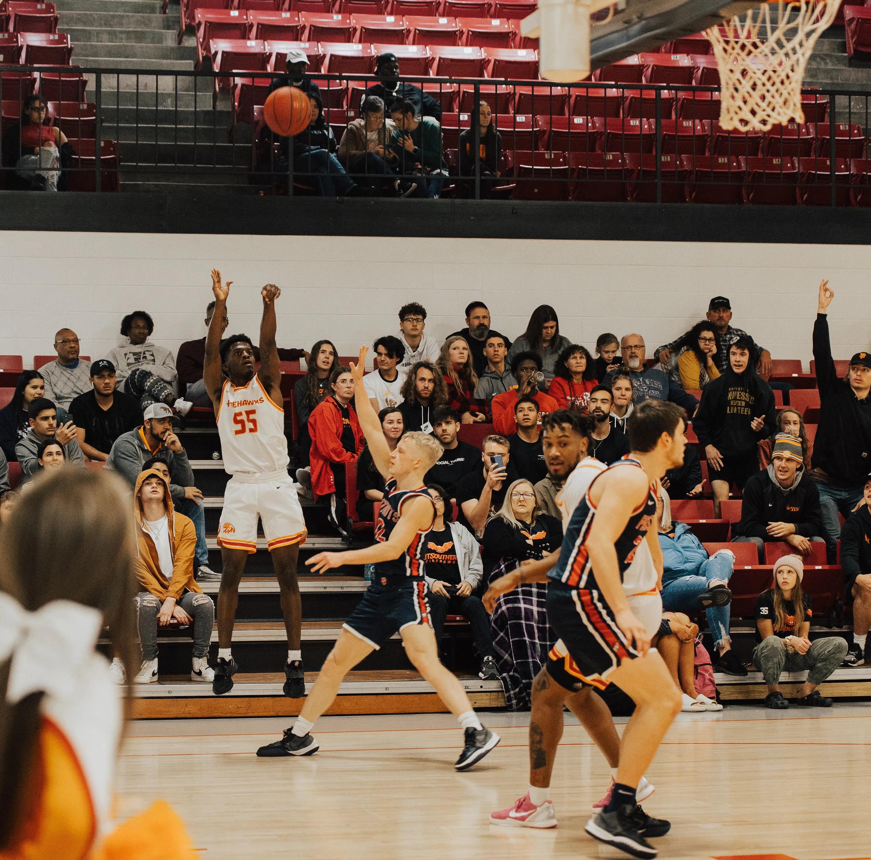 UT Southern Men's basketball team play a game in the gym with spectators in the stands. 