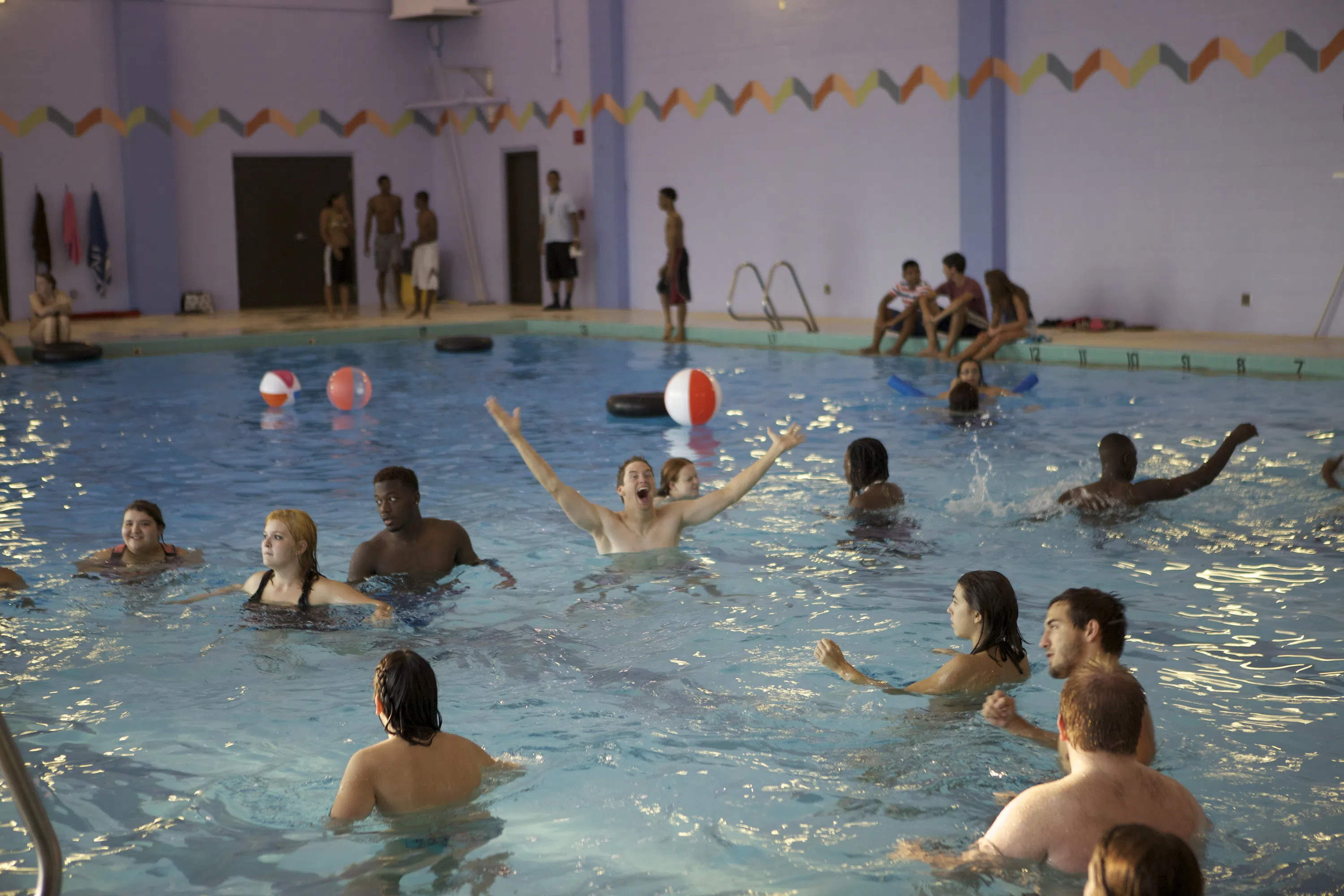 Students play games in the Curry Athletic Complex pool with beach balls and floats. 