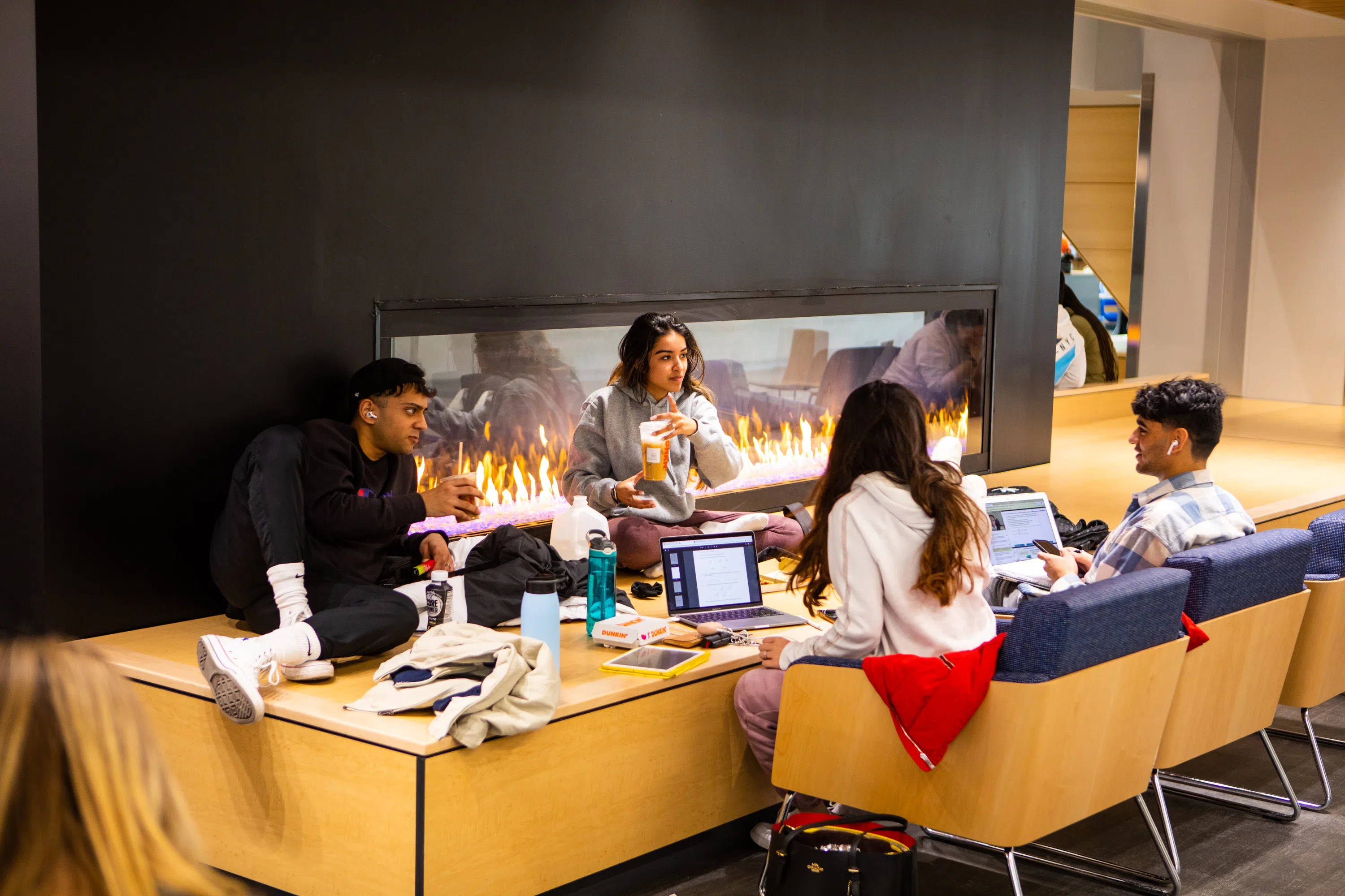 Students sitting near fireplace in One World Café