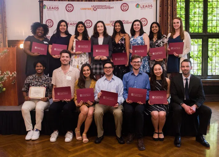 2 rows of 8 students stand in front of a "Center for Leadership and Involvement" backdrop, posing with award certificates