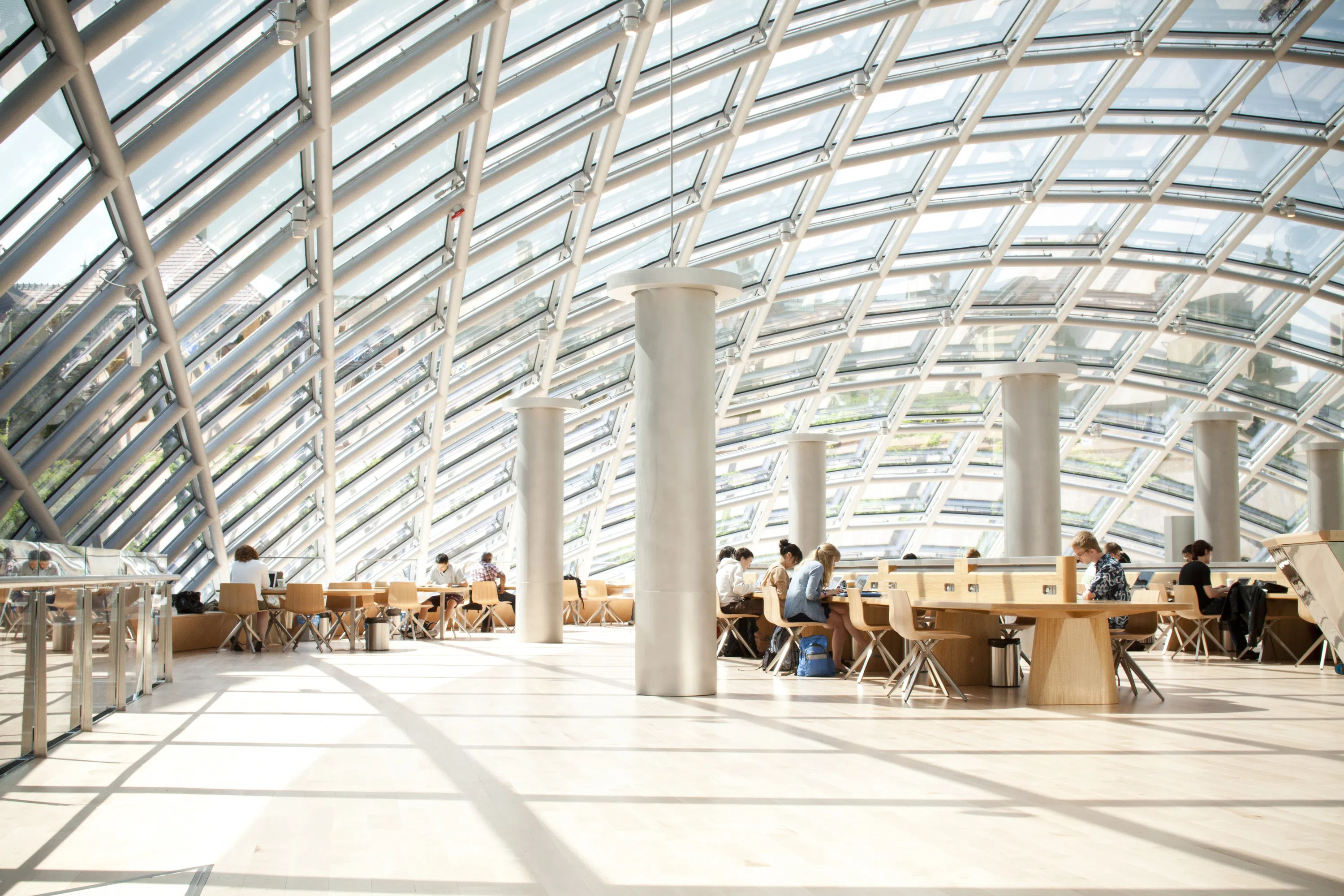 Interior of a large glass dome room with students sat at desks around the area