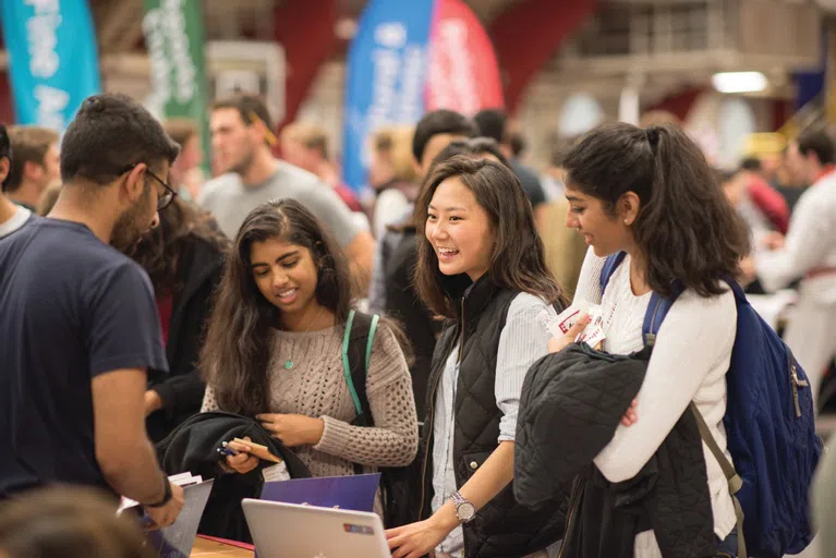 3 smiling students stand at a career fair stop 