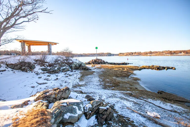 A snowy beach is adjacent to a stone kiosk