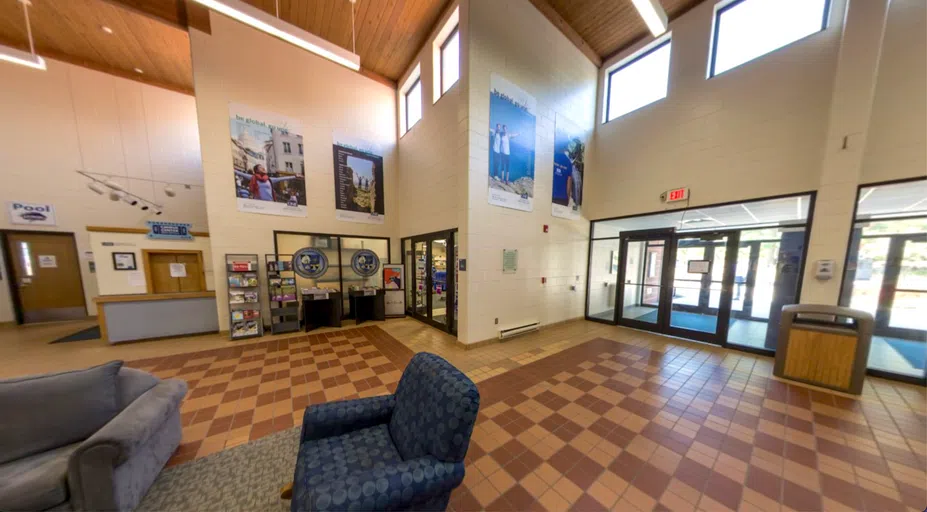 large room with couches. Doors to the exterior, bookstore, and pool are visible