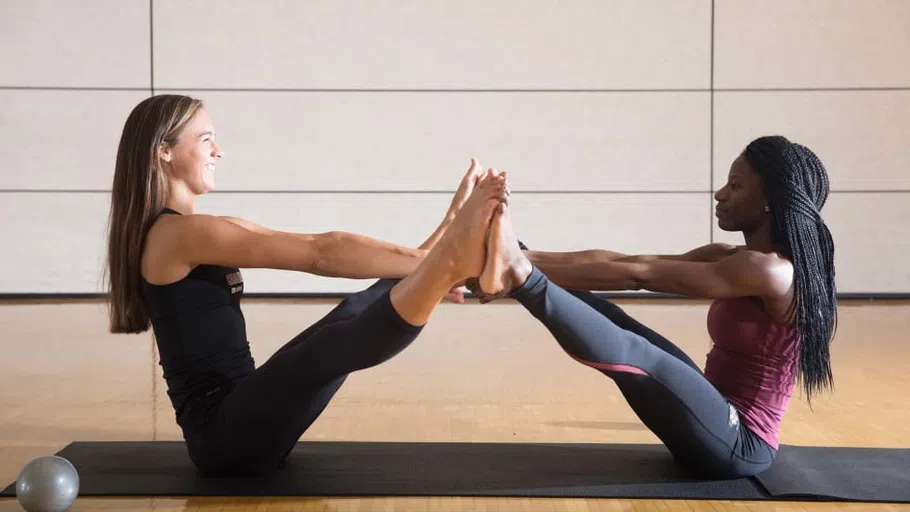 Two students have fun with a challenging yoga pose in one of the Strom’s exercise rooms.