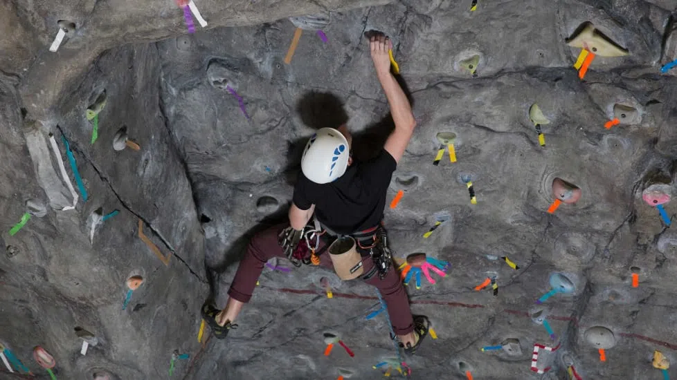 A student climbs the 52-foot rock wall in the middle of the wellness center.
