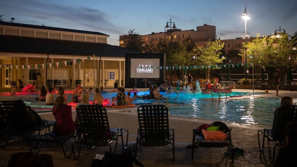 Students swim and float in the wellness center’s outdoor pool while watching a movie with friends.