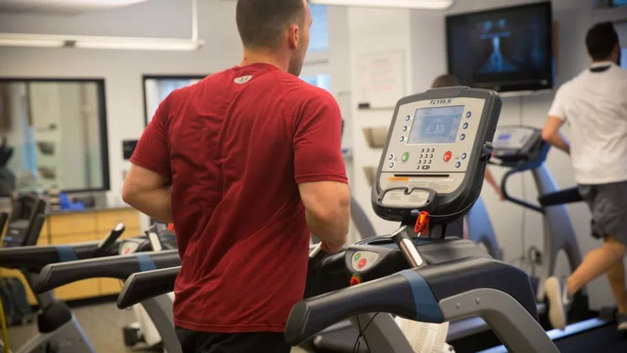 A student is monitored while running a treadmill.