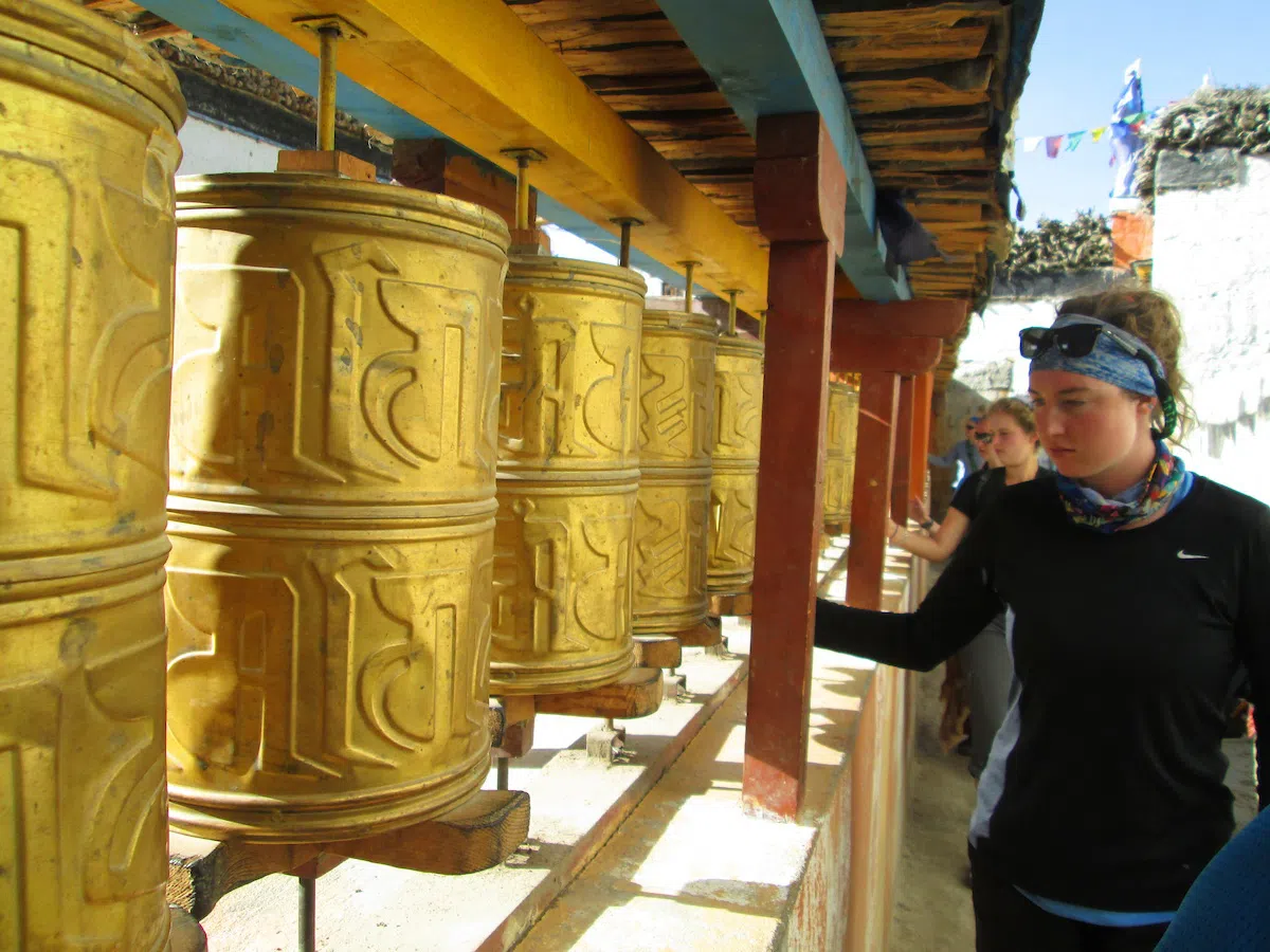 A UVM study abroad student looking at Tibetan bells while in Tibet.