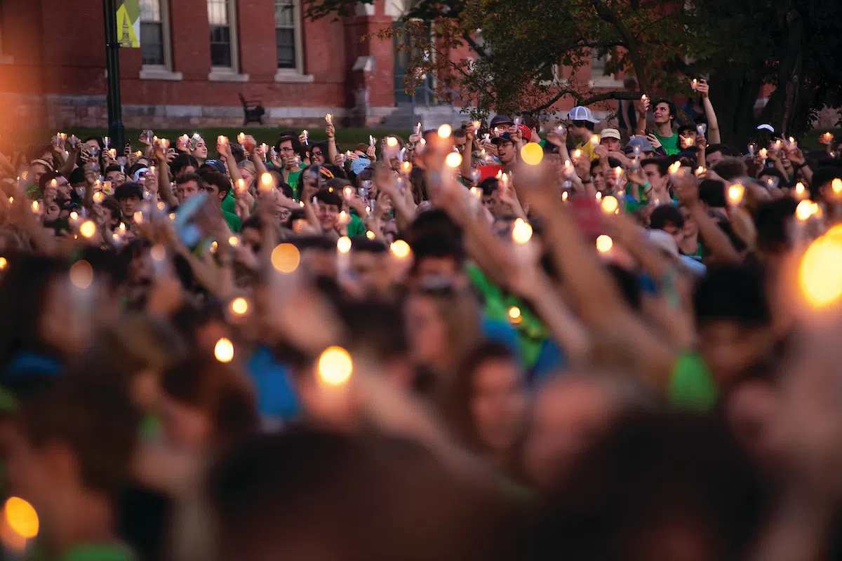 A large groups of students holding candles.