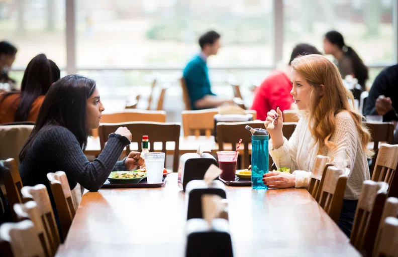 two students enjoying a meal at The Commons Dining Hall