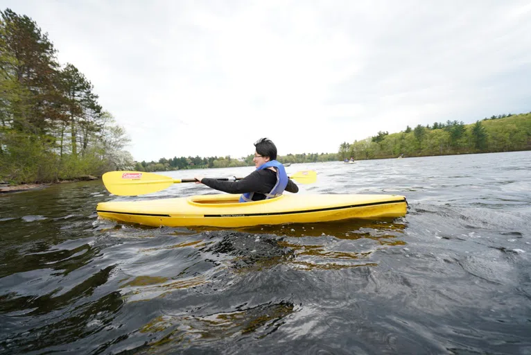 Wellesley student kayaking on Lake Waban