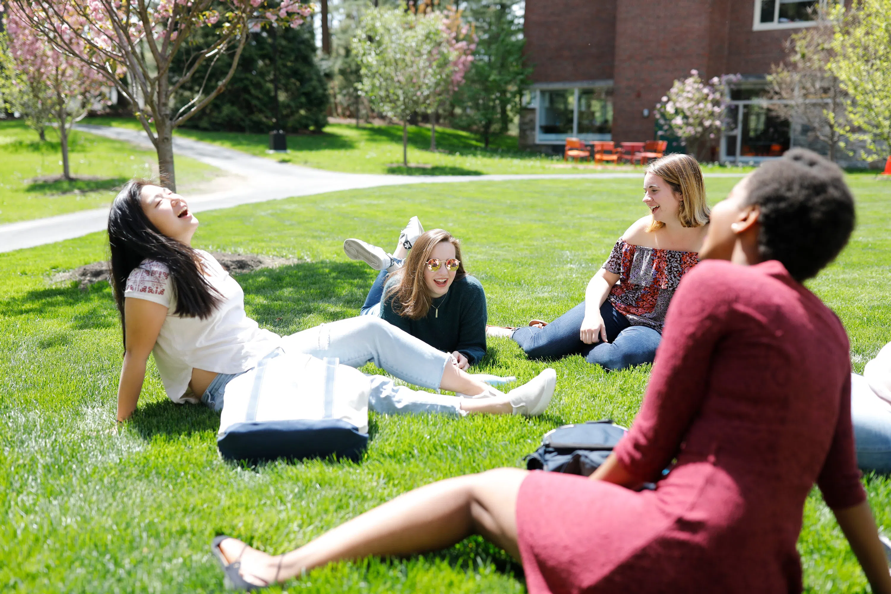 Wellesley students laughing out on the lawn