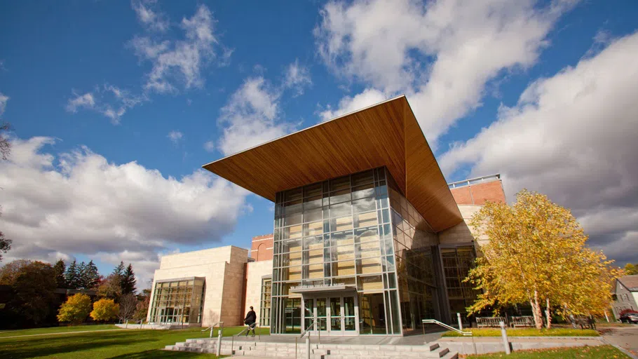 An image of the front of the '62 Center for Theater and Dance, a sleek modern building with plenty of open glass and wood finishes.